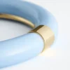 Brazalete de resina con detalles metálicos en contraste