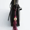 Dije de bolso con borla de cuero