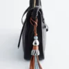 Dije de bolso con borla de cuero